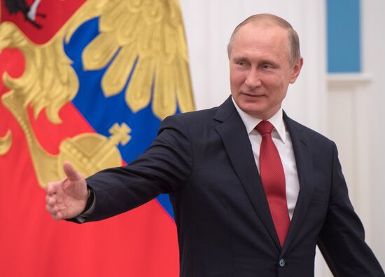 Russian President Vladimir Putin presents passports to young Russian citizens on Russia Day