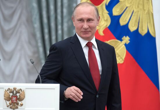 Russian President Vladimir Putin presents passports to young Russian citizens on Russia Day