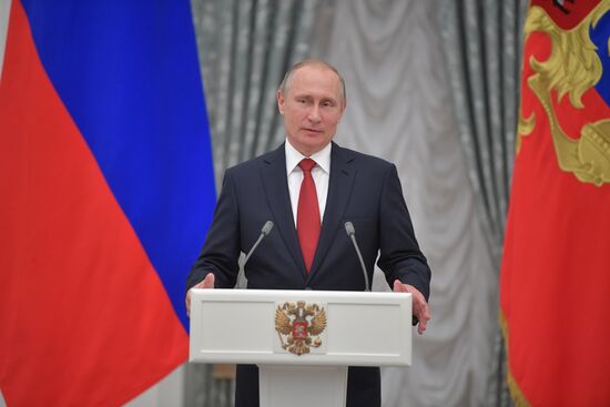 Russian President Vladimir Putin presents passports to young Russian citizens on Russia Day