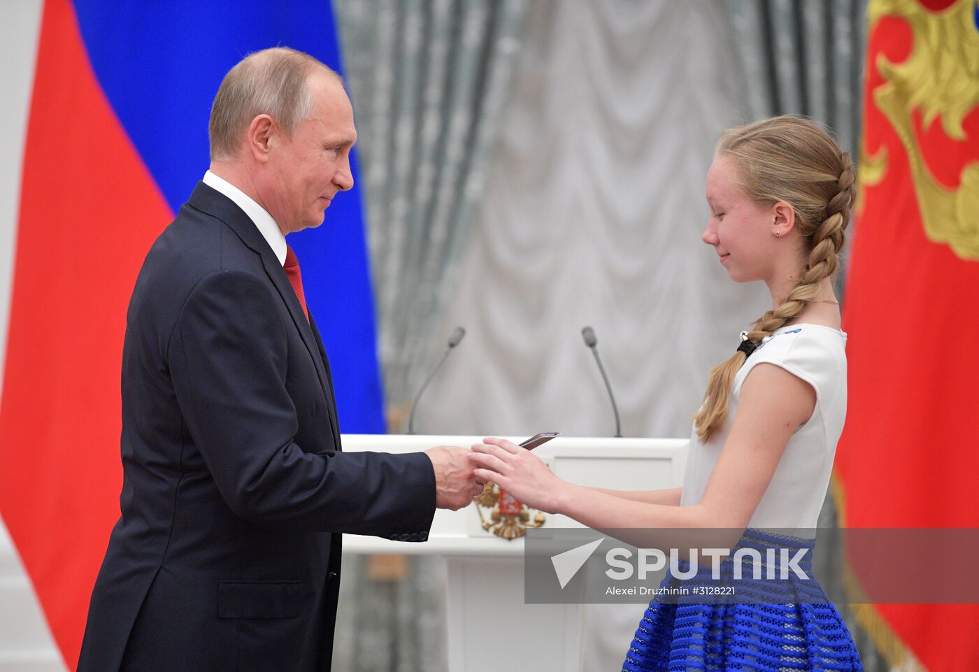 Russian President Vladimir Putin presents passports to young Russian citizens on Russia Day