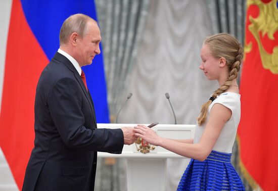 Russian President Vladimir Putin presents passports to young Russian citizens on Russia Day