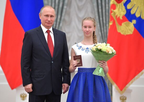 Russian President Vladimir Putin presents passports to young Russian citizens on Russia Day