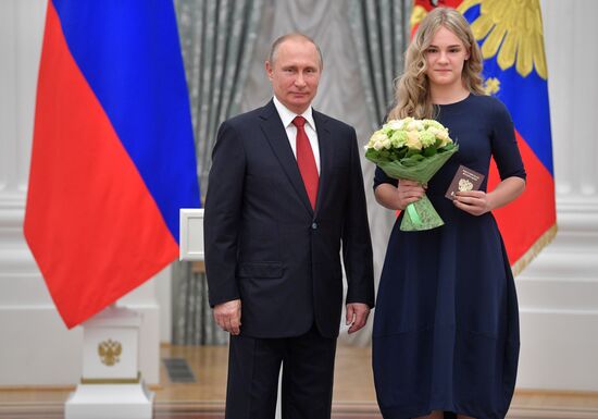 Russian President Vladimir Putin presents passports to young Russian citizens on Russia Day