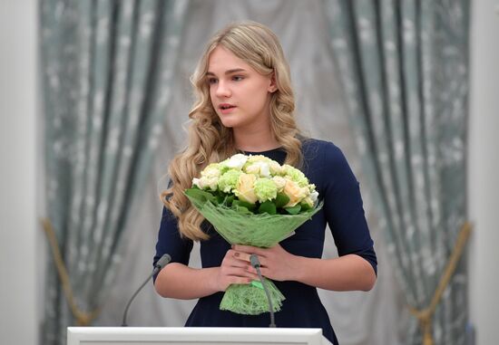 Russian President Vladimir Putin presents passports to young Russian citizens on Russia Day