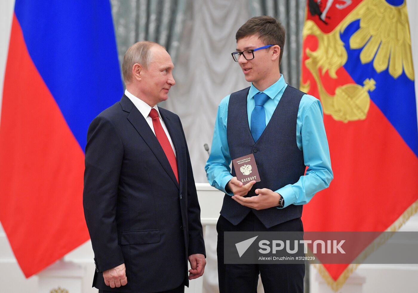 Russian President Vladimir Putin presents passports to young Russian citizens on Russia Day