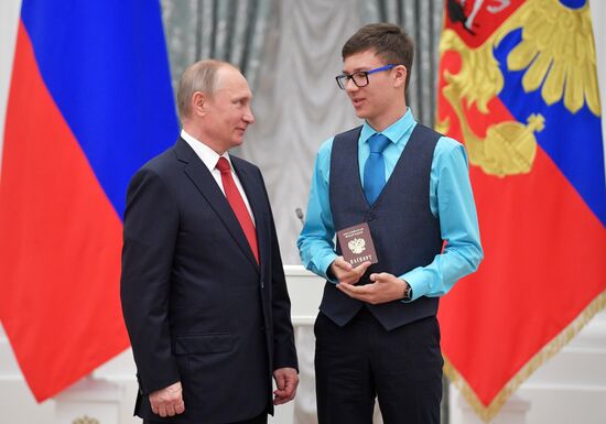 Russian President Vladimir Putin presents passports to young Russian citizens on Russia Day