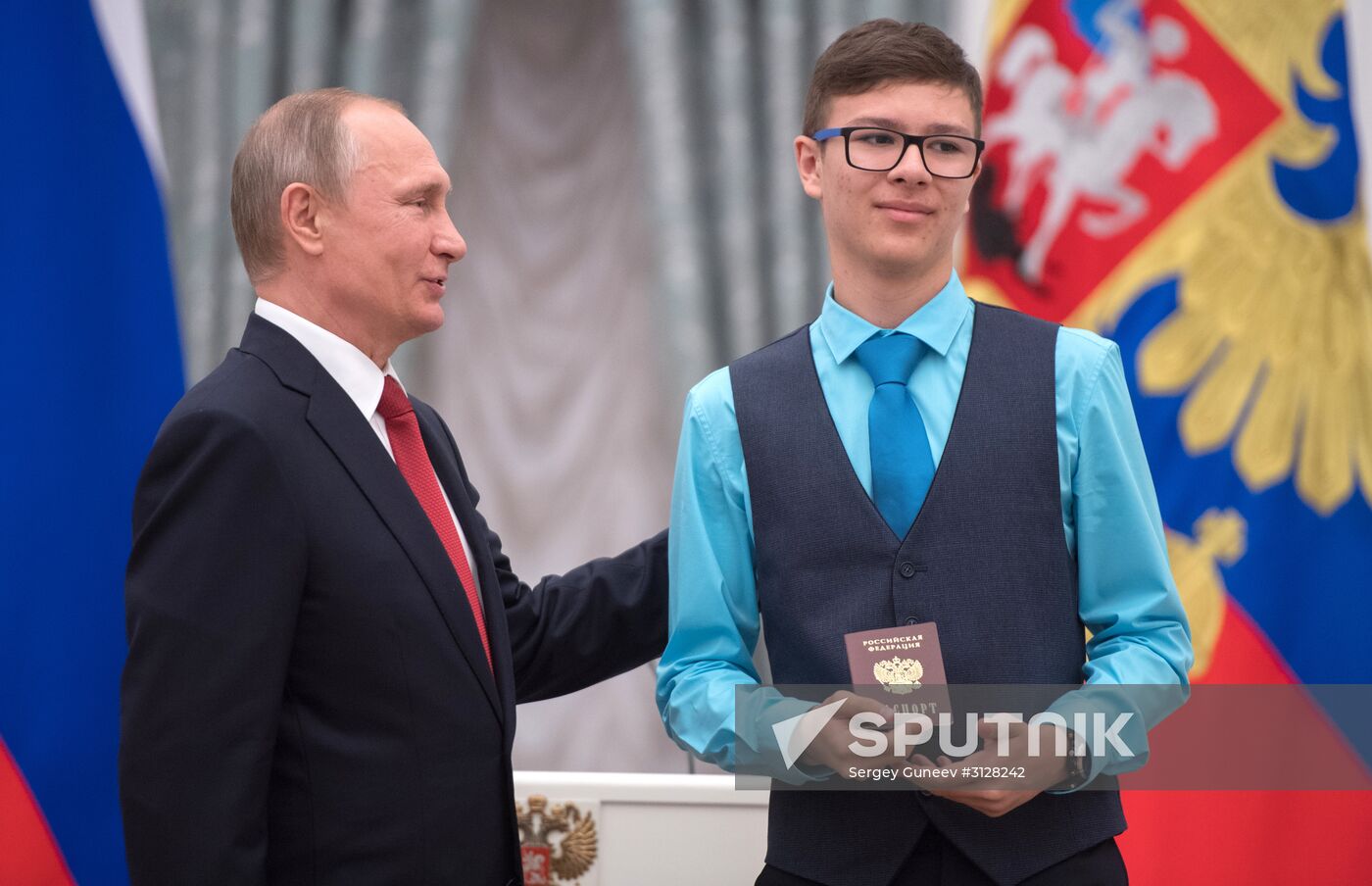 Russian President Vladimir Putin presents passports to young Russian citizens on Russia Day