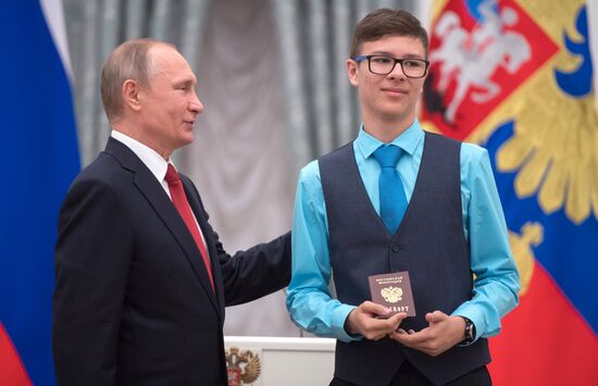Russian President Vladimir Putin presents passports to young Russian citizens on Russia Day