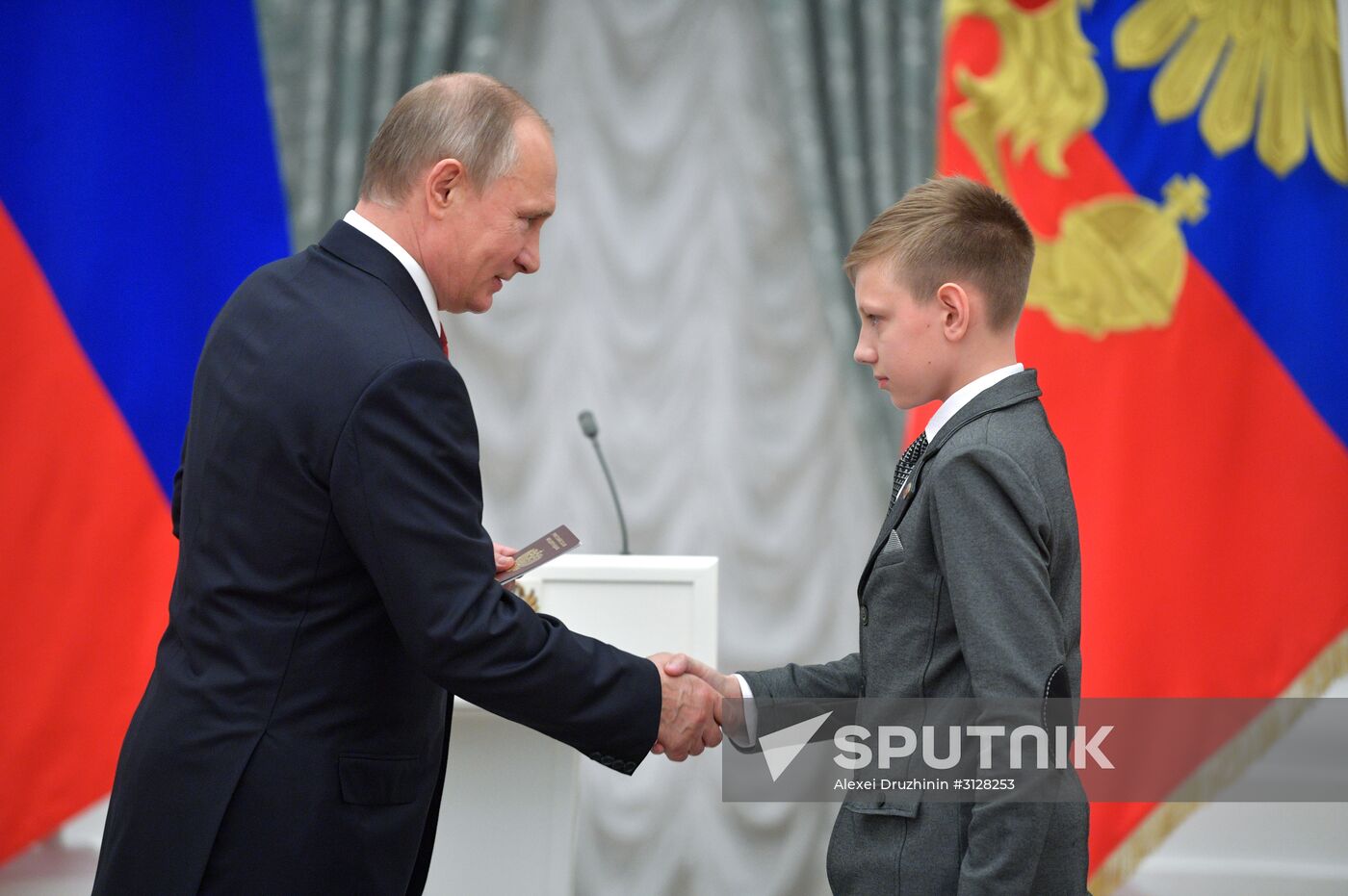 Russian President Vladimir Putin presents passports to young Russian citizens on Russia Day