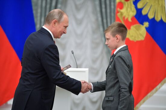 Russian President Vladimir Putin presents passports to young Russian citizens on Russia Day