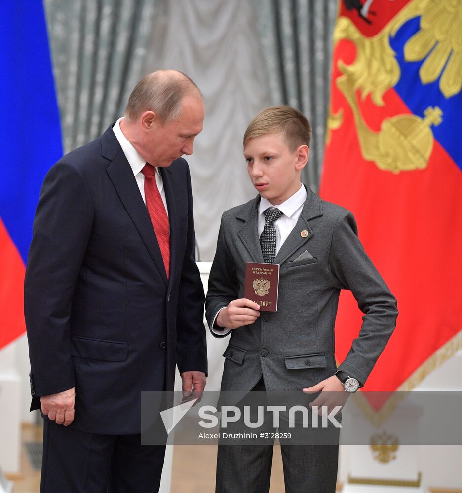 Russian President Vladimir Putin presents passports to young Russian citizens on Russia Day