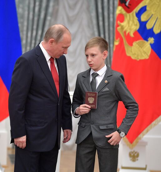 Russian President Vladimir Putin presents passports to young Russian citizens on Russia Day