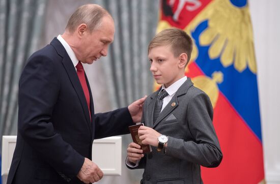 Russian President Vladimir Putin presents passports to young Russian citizens on Russia Day