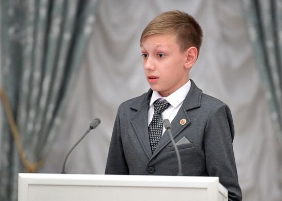 Russian President Vladimir Putin presents passports to young Russian citizens on Russia Day