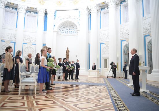 Russian President Vladimir Putin presents passports to young Russian citizens on Russia Day