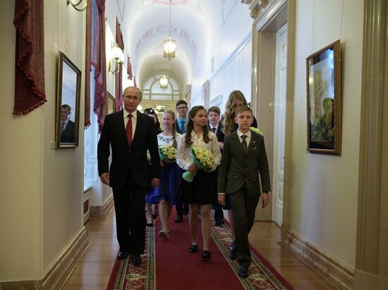 Russian President Vladimir Putin presents passports to young Russian citizens on Russia Day