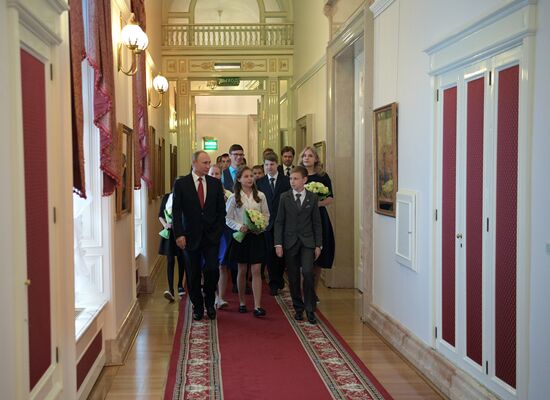 Russian President Vladimir Putin presents passports to young Russian citizens on Russia Day