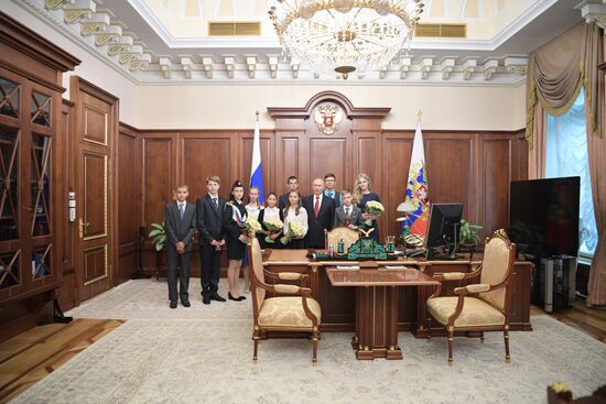 Russian President Vladimir Putin presents passports to young Russian citizens on Russia Day