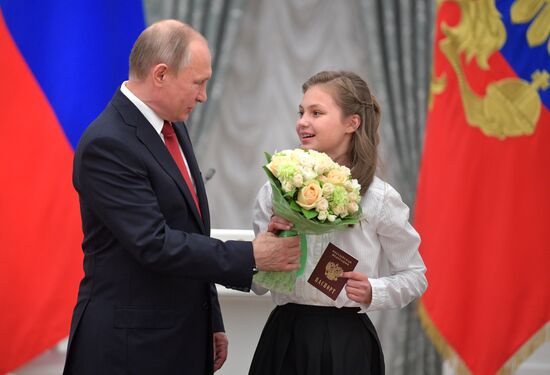 Russian President Vladimir Putin presents passports to young Russian citizens on Russia Day