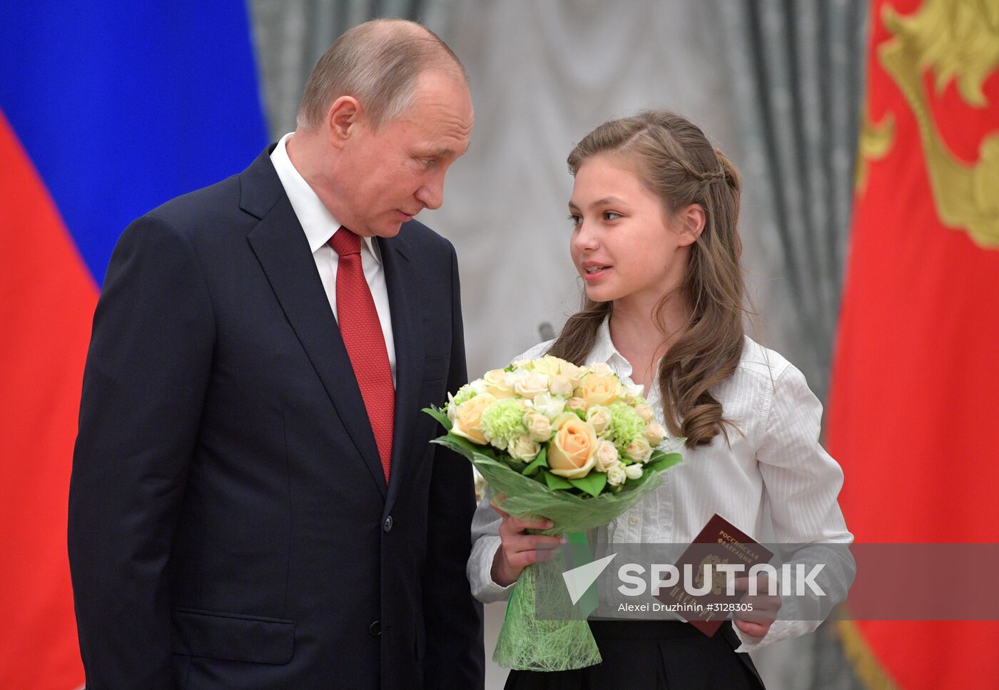 Russian President Vladimir Putin presents passports to young Russian citizens on Russia Day