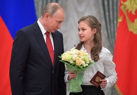 Russian President Vladimir Putin presents passports to young Russian citizens on Russia Day