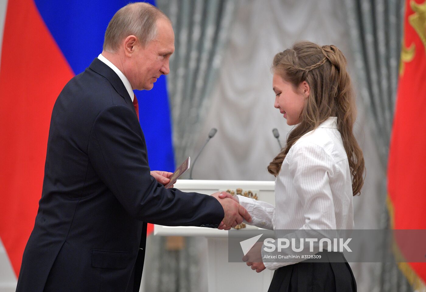 Russian President Vladimir Putin presents passports to young Russian citizens on Russia Day