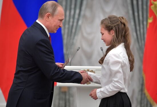 Russian President Vladimir Putin presents passports to young Russian citizens on Russia Day