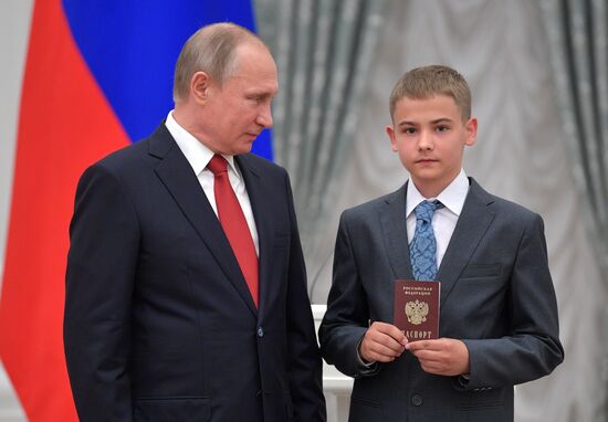 Russian President Vladimir Putin presents passports to young Russian citizens on Russia Day