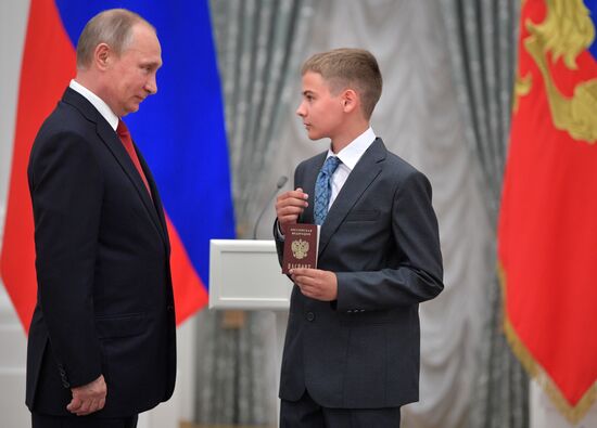 Russian President Vladimir Putin presents passports to young Russian citizens on Russia Day