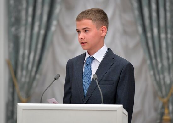 Russian President Vladimir Putin presents passports to young Russian citizens on Russia Day