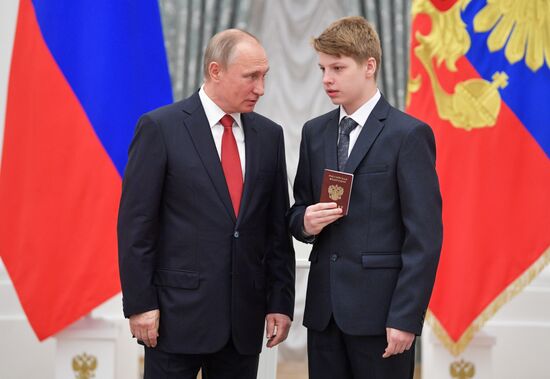 Russian President Vladimir Putin presents passports to young Russian citizens on Russia Day