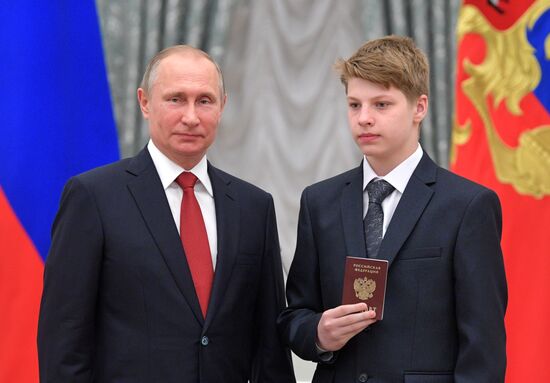 Russian President Vladimir Putin presents passports to young Russian citizens on Russia Day