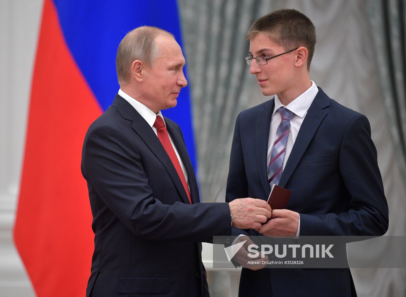 Russian President Vladimir Putin presents passports to young Russian citizens on Russia Day