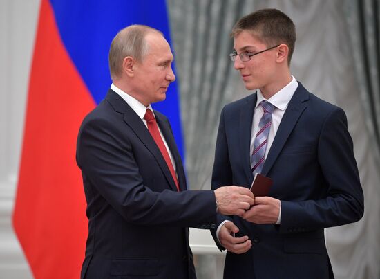 Russian President Vladimir Putin presents passports to young Russian citizens on Russia Day
