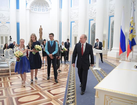 Russian President Vladimir Putin presents passports to young Russian citizens on Russia Day