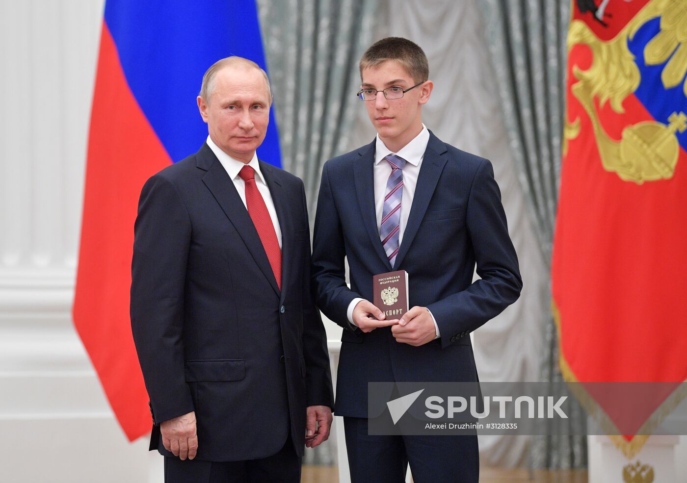 Russian President Vladimir Putin presents passports to young Russian citizens on Russia Day