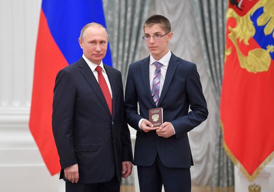 Russian President Vladimir Putin presents passports to young Russian citizens on Russia Day