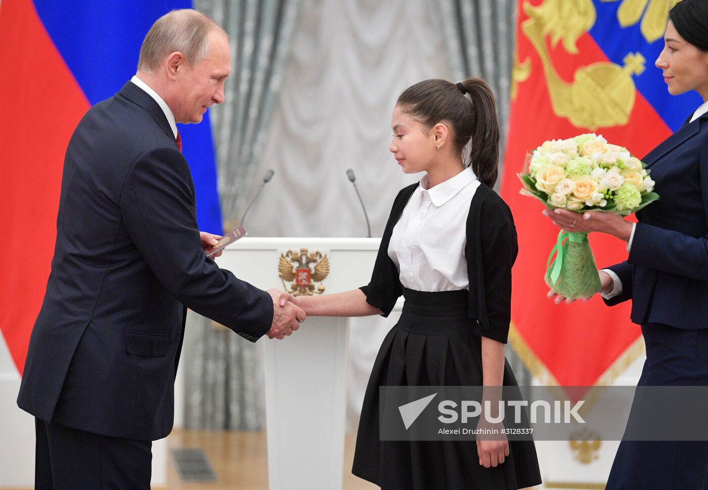 Russian President Vladimir Putin presents passports to young Russian citizens on Russia Day