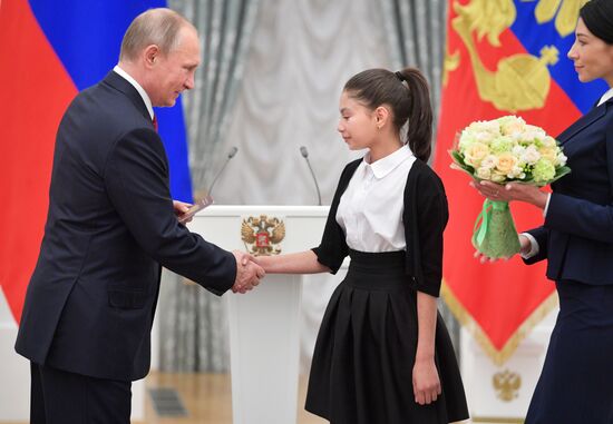 Russian President Vladimir Putin presents passports to young Russian citizens on Russia Day