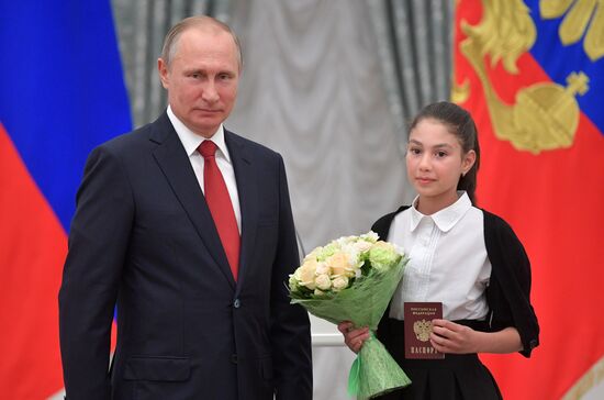 Russian President Vladimir Putin presents passports to young Russian citizens on Russia Day