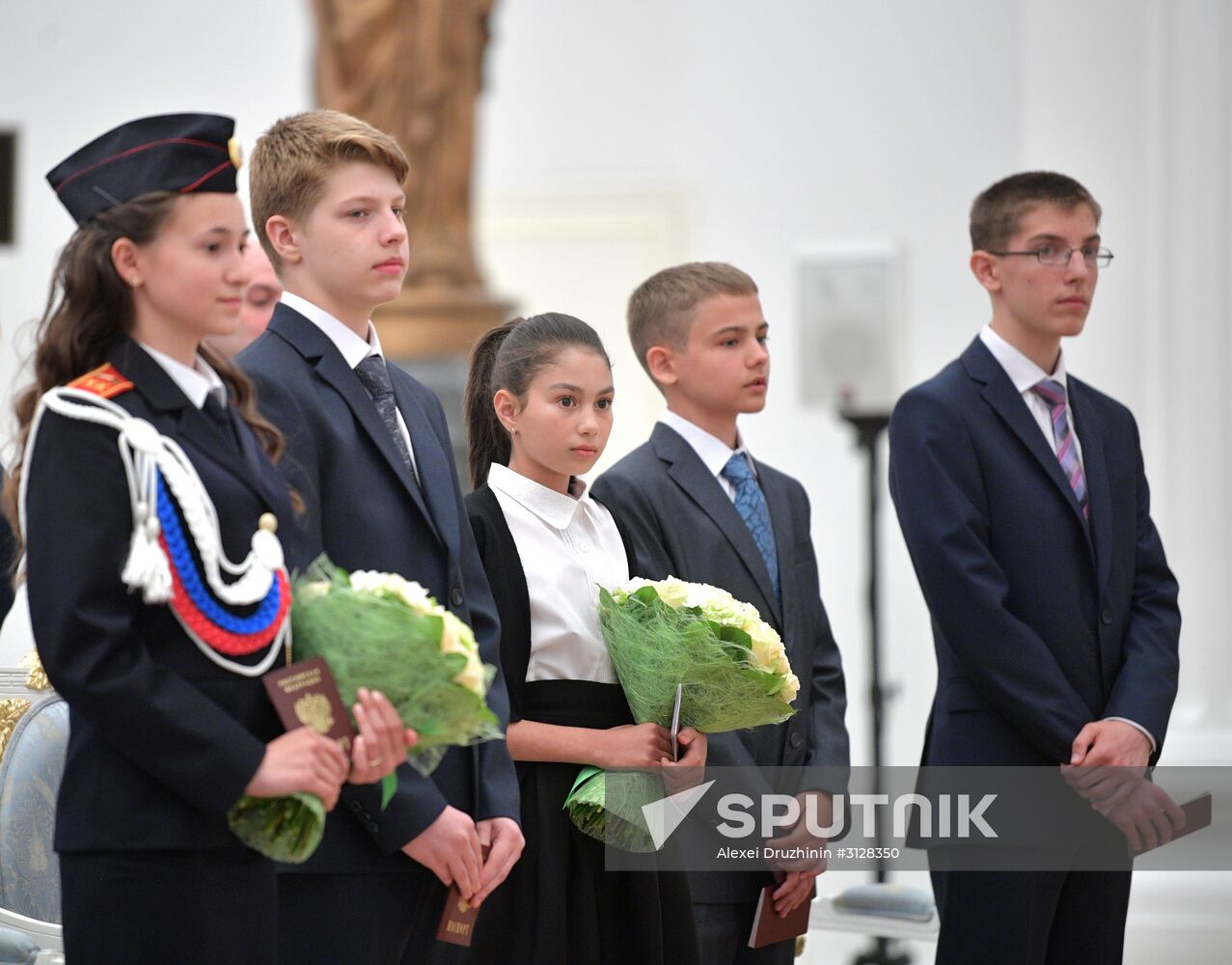 Russian President Vladimir Putin presents passports to young Russian citizens on Russia Day