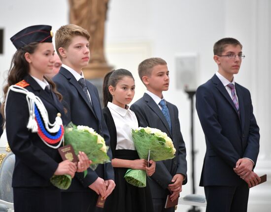 Russian President Vladimir Putin presents passports to young Russian citizens on Russia Day
