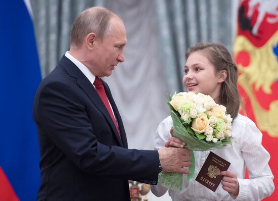 Russian President Vladimir Putin presents passports to young Russian citizens on Russia Day