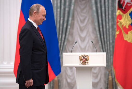 Russian President Vladimir Putin presents passports to young Russian citizens on Russia Day