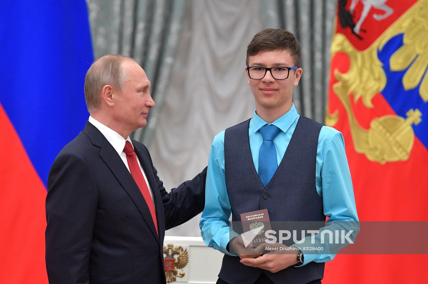 Russian President Vladimir Putin presents passports to young Russian citizens on Russia Day