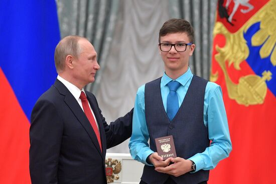 Russian President Vladimir Putin presents passports to young Russian citizens on Russia Day