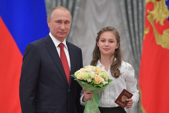 Russian President Vladimir Putin presents passports to young Russian citizens on Russia Day