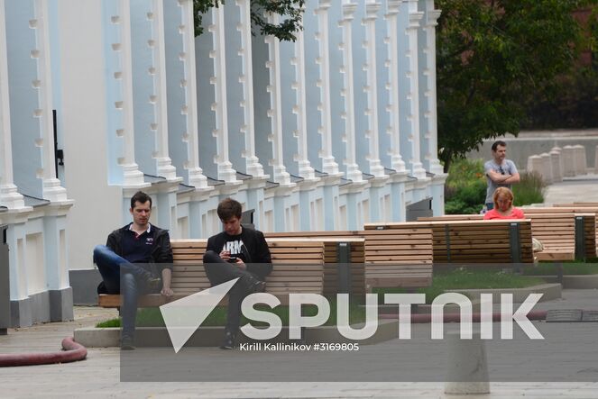 Young people sit on a bench in 3rd Golutvinsky Lane, Moscow. Location: Russia, Moscow. Author: Kirill Kallinikov/Sputnik. Improvement works on Moscow streets