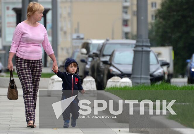 A woman with a child walk on Zhitnaya Street, Moscow. Location: Russia, Moscow. Author: Kirill Kallinikov/Sputnik. Improvement works on Moscow streets