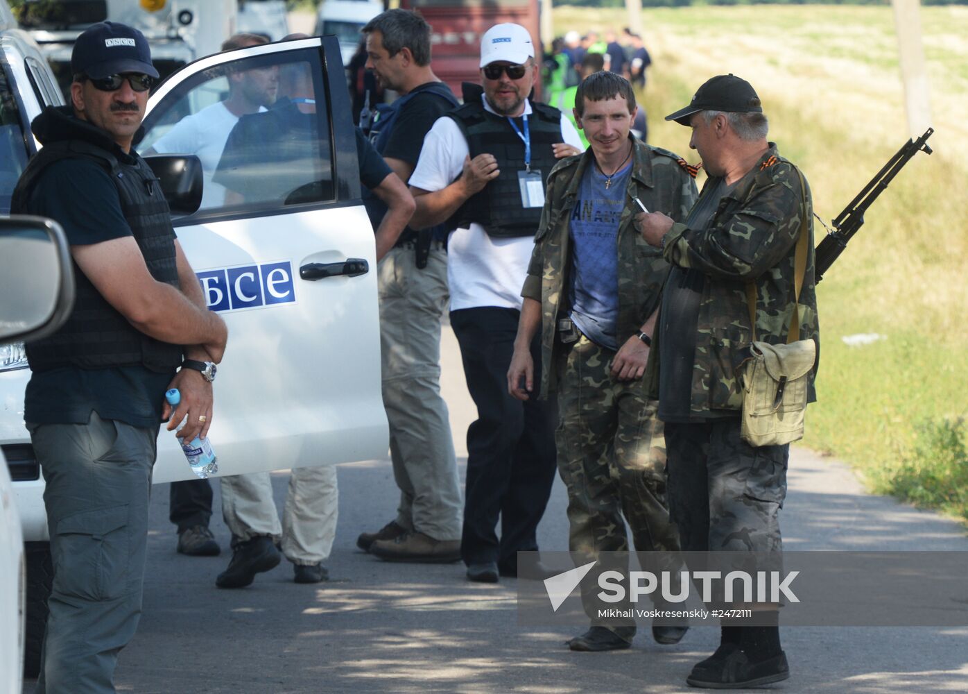 Experts and OSCE representatives work at MH17 crash site